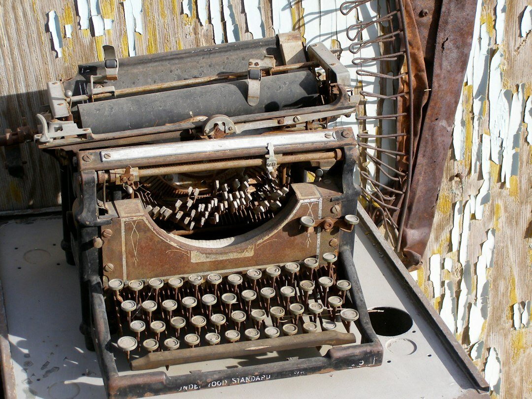 Vintage typewriter on a wooden desk with scattered pages
